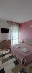 a bedroom with a bed with two towels on it at Albergo Drena in Drena