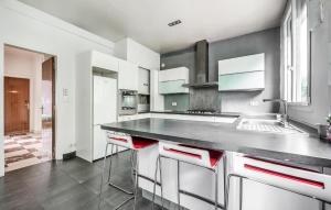 eine Küche mit weißen Schränken und einer Arbeitsplatte in der Unterkunft 4 Bedroom Cozy Apartment In Montreuil in Montreuil