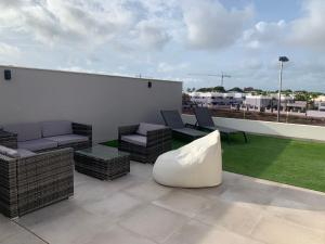 a patio with couches and chairs on a roof at Penthouse Las 2 Salchichas in San Javier