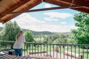 a woman standing on a balcony looking out at the mountains at Buchan Motel in Buchan