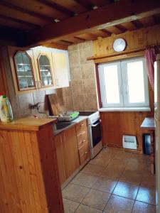 a small kitchen with wooden cabinets and a window at Chata TICHA in Oščadnica +20 photos