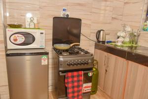 a kitchen with a microwave and a stove and a refrigerator at g and m luxe Abode in Nyeri
