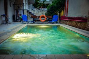 a swimming pool with chairs and an orange life preserver at Erifili Kallithea in Kallithea Halkidikis