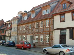 eine Reihe von Häusern mit vor ihnen geparkt in der Unterkunft Apartmenthaus im Augustinern in Quedlinburg