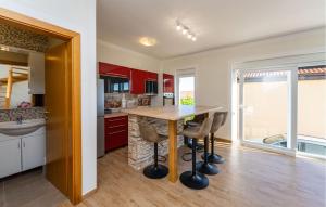 a kitchen with red cabinets and a wooden table at Beautiful Apartment In Rtina With Wifi in Rtina