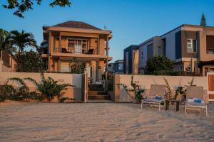 a house with two chairs in front of it at The Compound - Villa 3 in Baie du Tombeau
