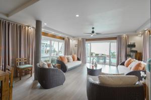 a living room with a couch and chairs and a table at The Compound - Villa 3 in Baie du Tombeau