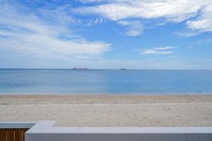 a view of the beach with a ship in the distance at The Compound - Villa 3 in Baie du Tombeau