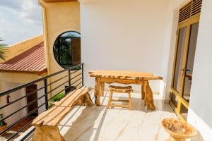 a balcony with a wooden bench and a table at High Ground Villa Ltd in Kigali