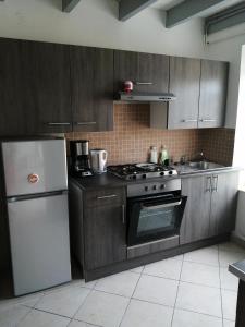 a kitchen with a stove and a refrigerator at le petit hameau in Fontenay-sur-Mer