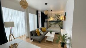 a living room with a couch and a bed at Cosy Green - T1 - 35 m2 in Lourdes