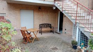 un patio con tavolo, sedie e panca di Appartamento bilocale ERICA a Monteriggioni