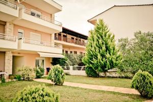 an apartment building with two trees in a yard at Erifili Kallithea in Kallithea Halkidikis