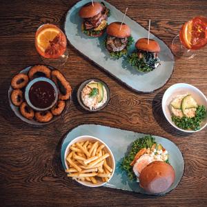 a table topped with plates of food and bowls of fries at Benztown Hotel Gästehaus in Stuttgart