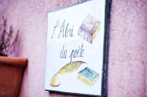 a sign hanging on a wall with an umbrella at L'Abri du Poète in Besse-sur-Issole