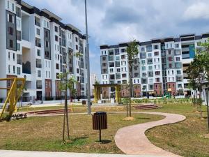 a park with a playground and apartment buildings at AINOR@Stay Homestay Sendayan in Labu