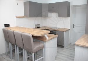 a kitchen with a wooden table and chairs at L'Echappée Provençale - 4 Etoiles in Saint-Laurent-des-Arbres
