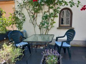 a patio with a table and two chairs and a window at Ferienwohnung Moselsteig in Reil