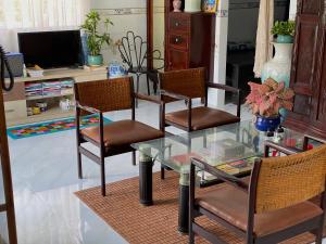 a glass table and chairs in a living room at PHẠM Homestay Ca Mau in Thới Bình