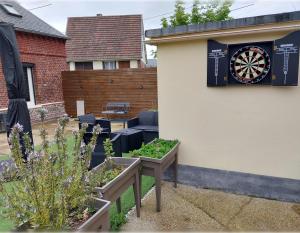 a garden with a dart board on the side of a building at Maison de charme à Dieppe, confort et loisirs in Dieppe