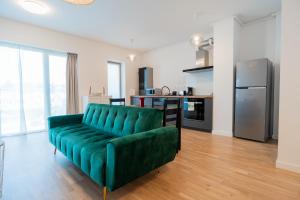 un divano verde in un soggiorno con cucina di Lagoon Park Apartments with Beach View a Bucarest