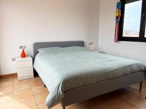 a bedroom with a bed with a green comforter and a window at Casa Solayla Origomare in Lajares