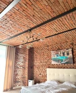 a bedroom with a brick wall with a green car on the wall at Apartament JOYSO LIFE&SPA Brasov - Couples Only in Braşov