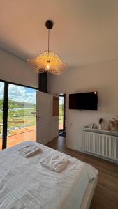 a bedroom with a large bed and a chandelier at Story Cabin Lake in Cîmpeneşti +33 photos