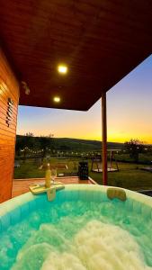 a hot tub with a sunset in the background at Story Cabin Lake in Cîmpeneşti
