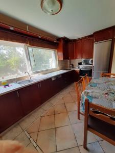 a kitchen with wooden cabinets and a table with a sink and a refrigerator at Seaside paradise in Iraklitsa