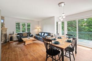 un salon avec une table, des chaises et un canapé dans l'établissement Townhouse On The Golf W Pool Access -aiglon 1748, à Mont-Tremblant