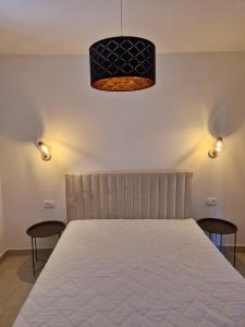 1 Schlafzimmer mit einem weißen Bett mit 2 Stühlen in der Unterkunft Holiday Home Nino with amazing swimming pool in Slatine + 40 Fotos