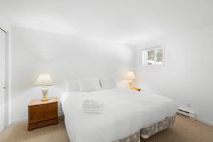- une chambre blanche avec un grand lit blanc et deux lampes dans l'établissement Townhouse On The Golf W Pool Access -aiglon 1748, à Mont-Tremblant 18 autres photos