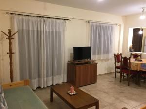 a living room with a tv and a table at Ηρεμία - Φύση in Kastanéa