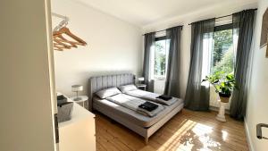 a bedroom with a bed and two windows at Apartment Savanna im historischen Stadtkern Linn in Krefeld, nähe Düsseldorf Messe, Airport, Parkmöglichkeiten direkt vor dem Haus in Krefeld