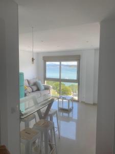 Una sala de estar blanca con un sofá y una mesa. en Luz de Mar, en O Grove