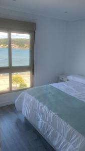 Un dormitorio con una cama grande y una ventana grande en Luz de Mar, en O Grove