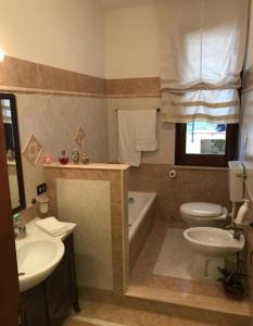 a bathroom with a tub and a toilet and a sink at La villa di Turi in Castellammare del Golfo