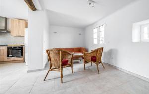ムリエスにある3 Bedroom Gorgeous Home In Mourièsのテーブルと椅子2脚のあるダイニングルーム