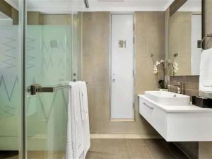 ヨハネスブルグにあるApartment Towers in Sandton- with luxury Spaのガラスのシャワーと洗面台を備えたバスルーム +8枚の写真