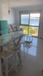 Una sala de estar con una mesa de cristal y un sofá. en Luz de Mar, en O Grove