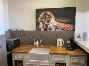 un comptoir de cuisine avec une peinture représentant une tasse de café dans l'établissement C-view Holiday, à Middelkerke