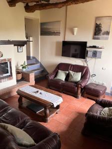 a living room with leather couches and a coffee table at Casa Cielo in Pescia