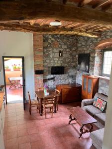 a living room with a table and a stone wall at Casa Cielo in Pescia