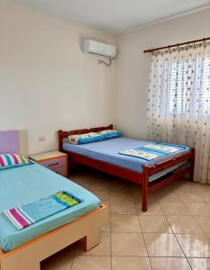 a bedroom with two beds and a window at Vineyard Villa in Himare