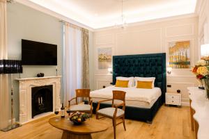 a bedroom with a king sized bed and a fireplace at Curcumelli Luxury Suites in Corfu Town