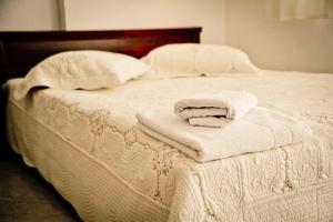 a bed with white blankets and pillows on it at Erifili Kallithea in Kallithea Halkidikis