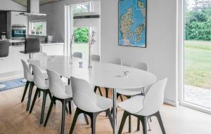 a white dining room with a white table and chairs at Holiday Home Bronzehøjen Højslev in Bøstrup