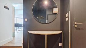 a hallway with a table and a mirror on the wall at Résidence du Théâtre, appartements avec ou sans SPA in Moulins +79 photos