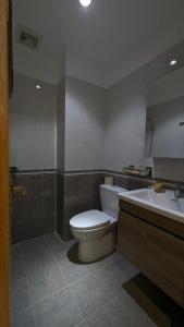 a bathroom with a toilet and a sink and a mirror at High-class apartment with beautiful river view in Long Xuyên